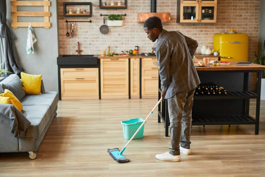 How to Clean Hardwood Floors - Man cleaning hardwood floors in his home