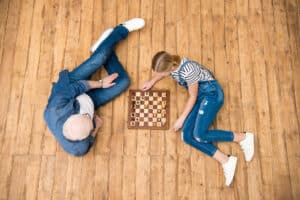 How to Clean Hardwood Floors - Grandpa and daughter playing chess on hardwood floors